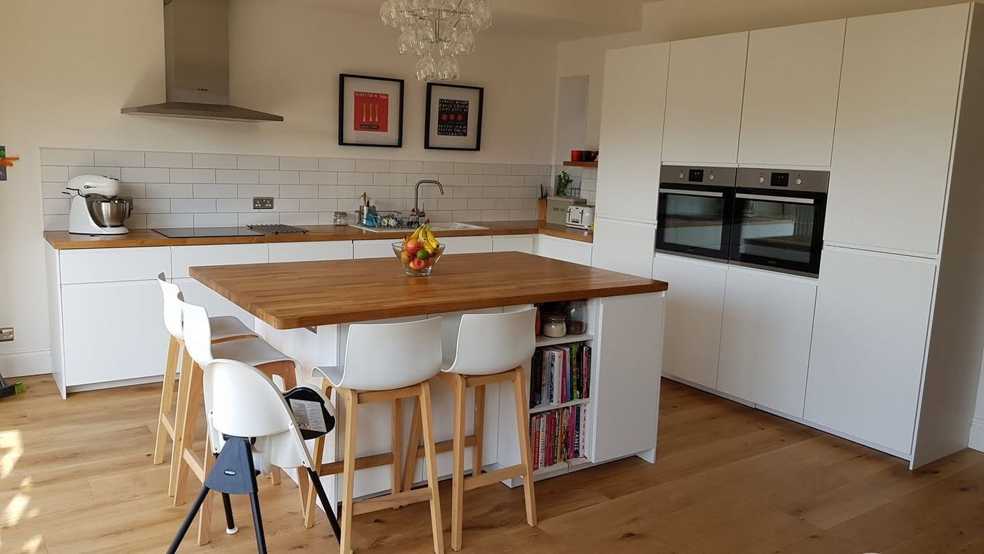 White kitchen with oak worktop island fitted by PJB