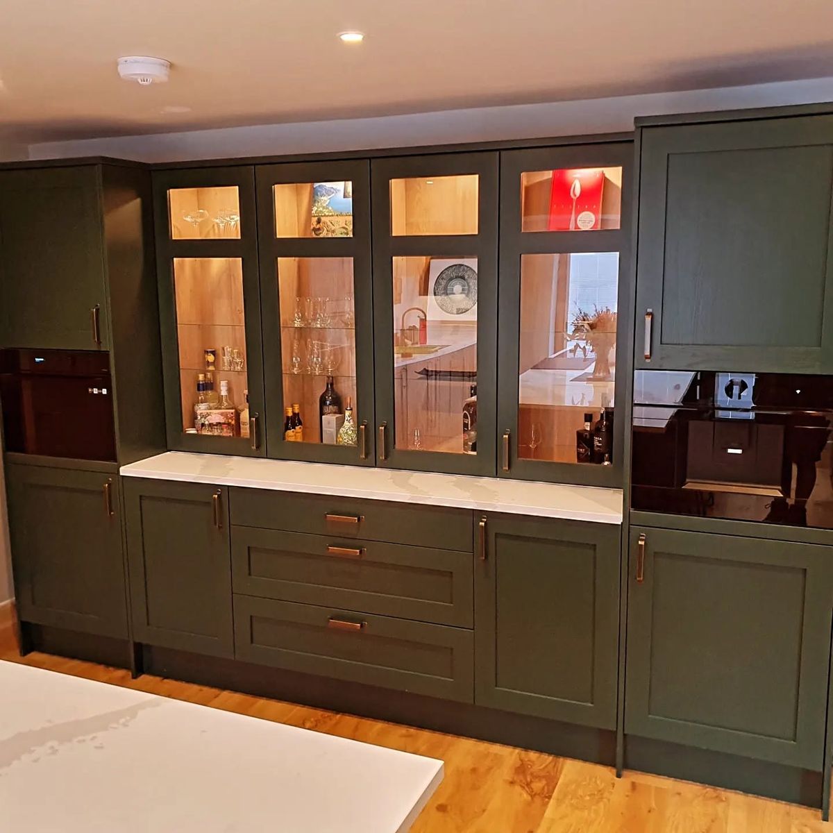 Fitted media and drinks unit with lit glass display by PJB joiners